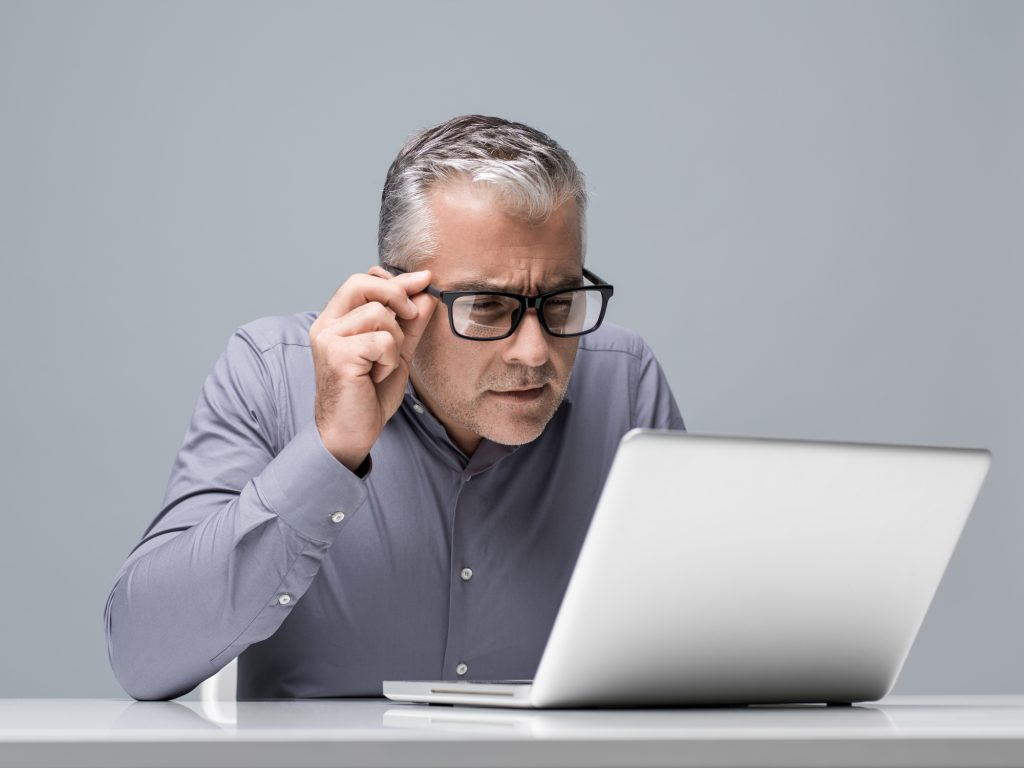 Squinting at laptop needing new glasses